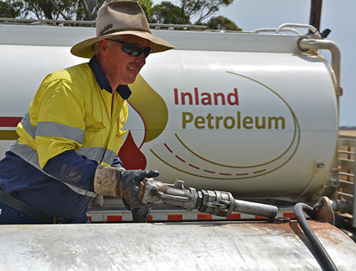 Man filling Inland Petroleum fuel tank